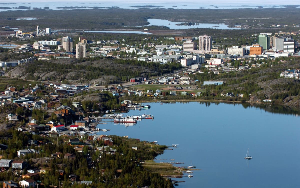 A view of the city from above shows a lake, buildings and boats.