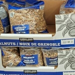 A display of walnuts in packages on top of cardboard.