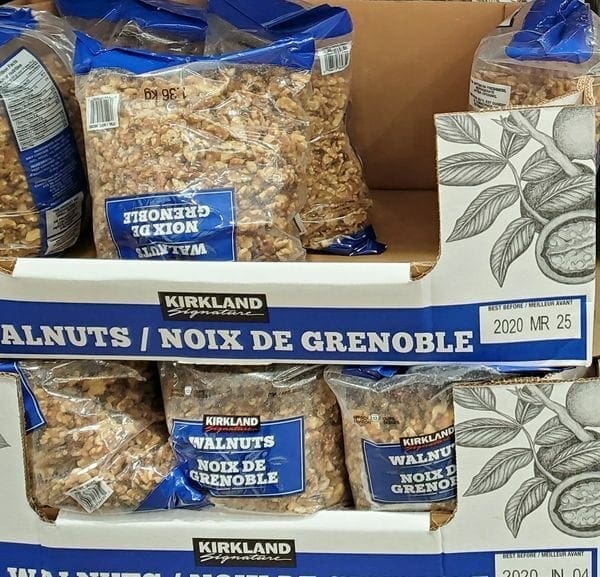 A display of walnuts in packages on top of cardboard.