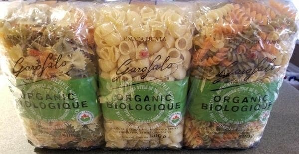 Three bags of pasta sitting on a counter.