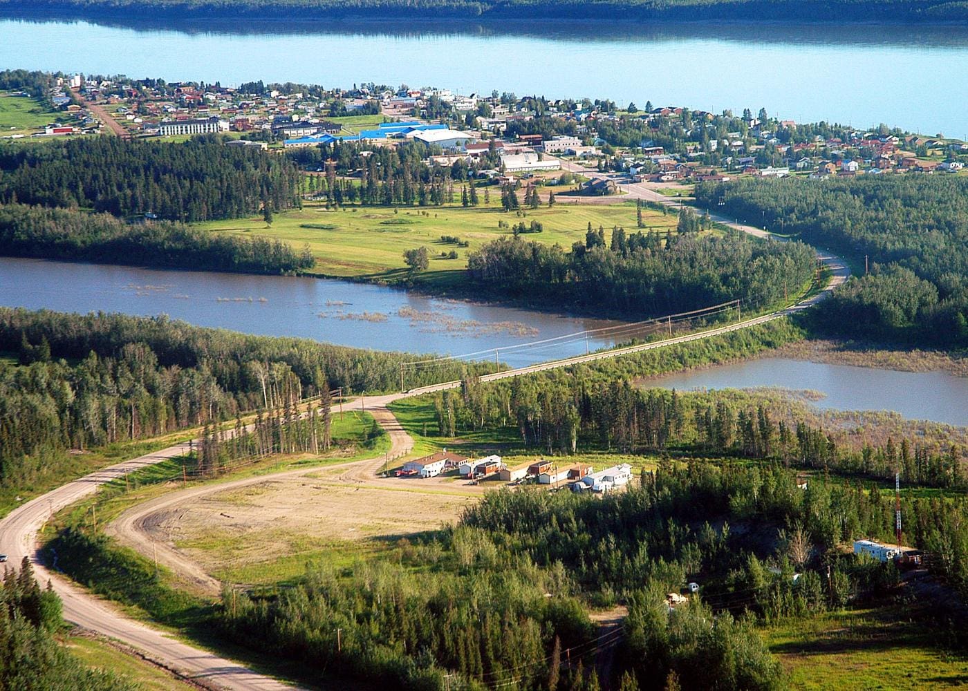 A view of the water from above shows a road, houses and trees.