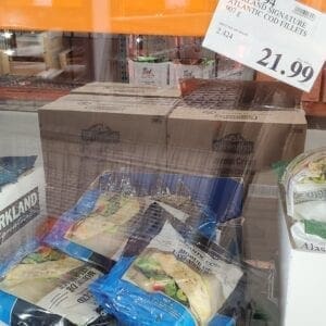 A store window with boxes of food and a price sign.