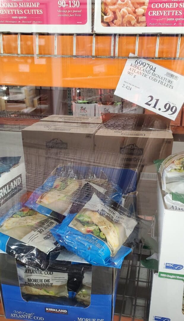 A store window with boxes of food and a price sign.