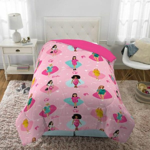 A pink Mattel Barbie Sunset Dreams Comforter with pink and blue princesses on it.