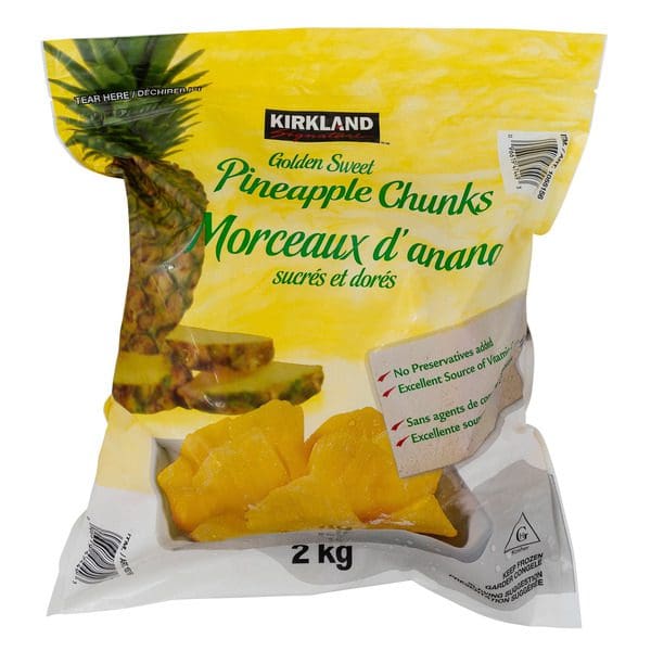 A bag of Kirkland Signature Golden Sweet Pineapple Chunks on a white background.